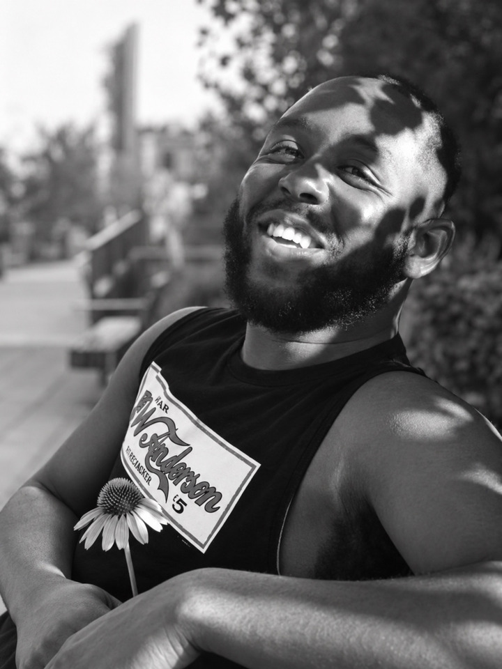 Karim smiling with a flower
